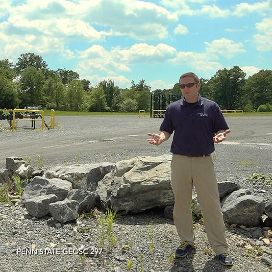 Professor talking. Oil storage tank is in the background.