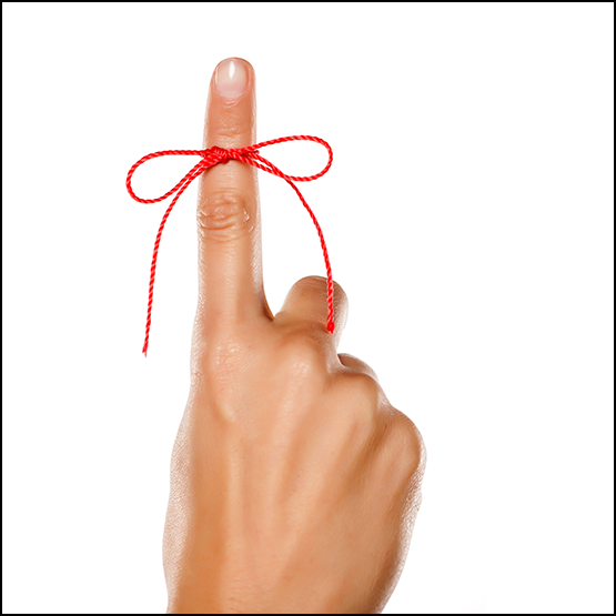 hand with red yarn tied around one finger